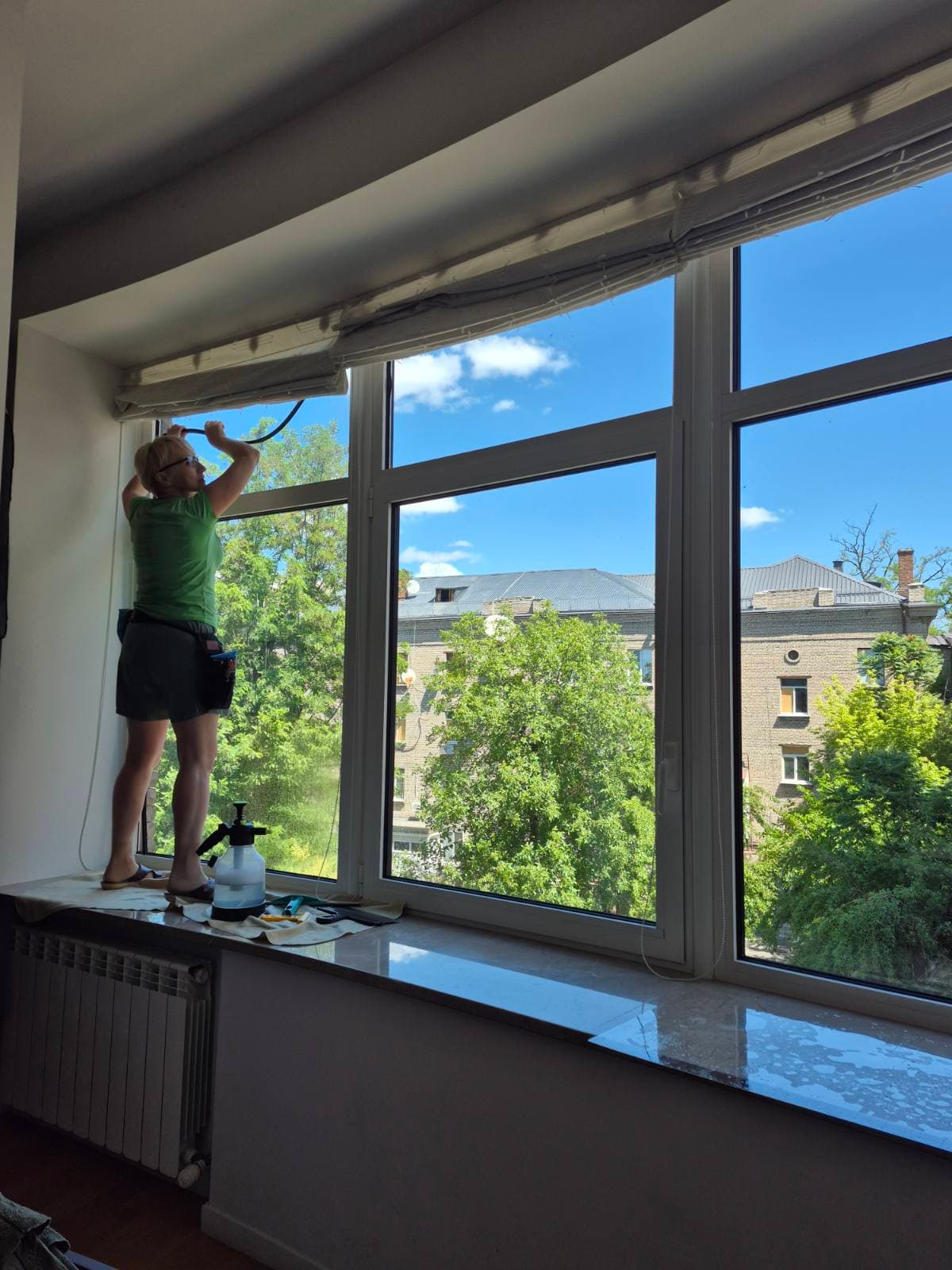 Майстер клеїть плівку на вікна офісного приміщення